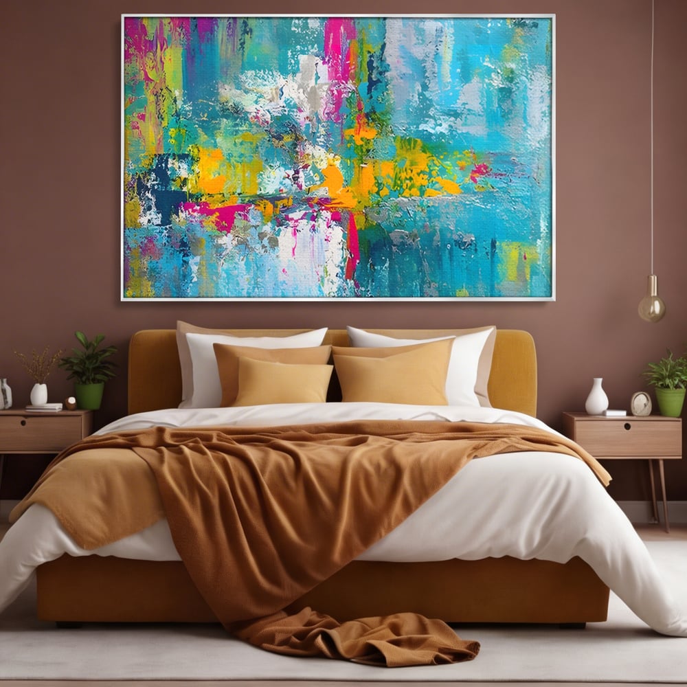 Tablou canvas cu pictura abstracta cu pete albastre si galbene, in rama de aluminiu argintiu, pe perete intr-un dormitor